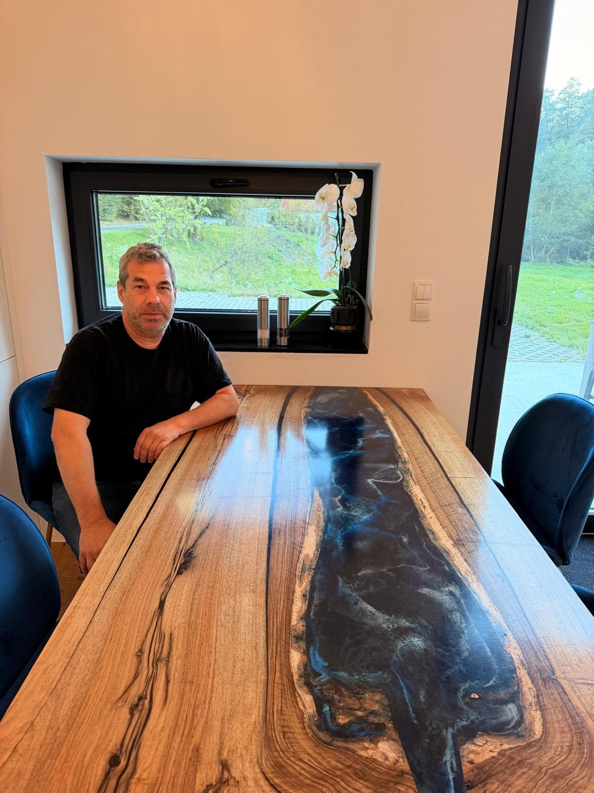 Markus Schneider, Gründer von ART massive, an einem seiner handgefertigten Unikat-Tische aus Holz und Kunstharz